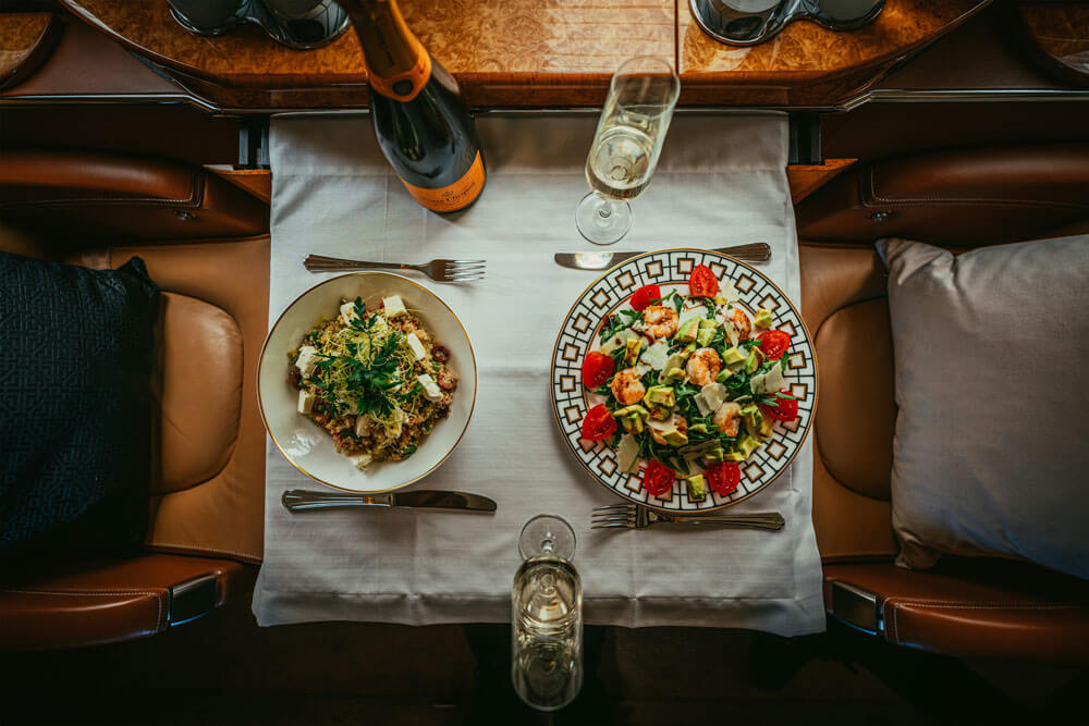 Champagne and luxury in-flight catering aboard a private jet booked through Dela World Charter.