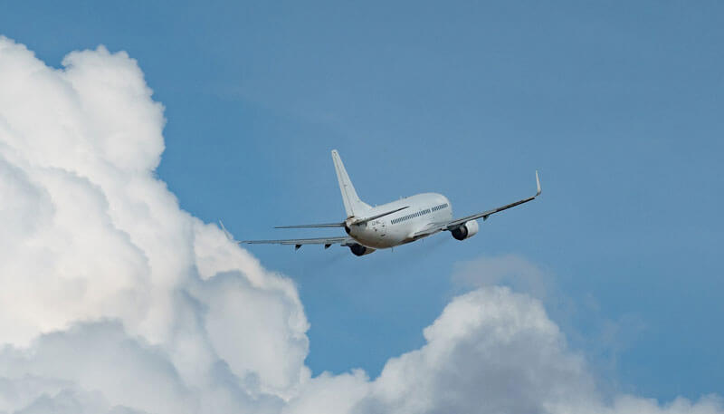 A commercial charter aircraft operated by Dela World Charter flying through the sky.