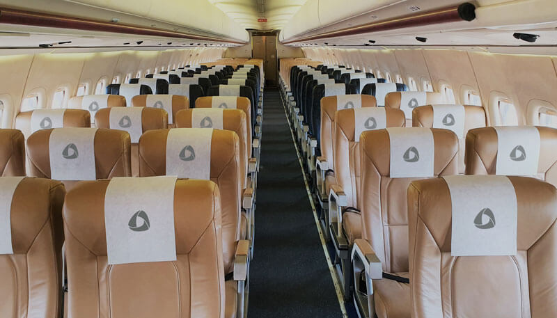 Commercial aircraft headrests designed with custom logo covers by Dela World Charter.