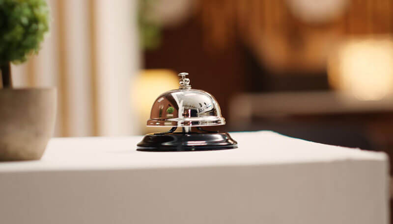 A bell on the desk of a hotel reception for a concierge service.